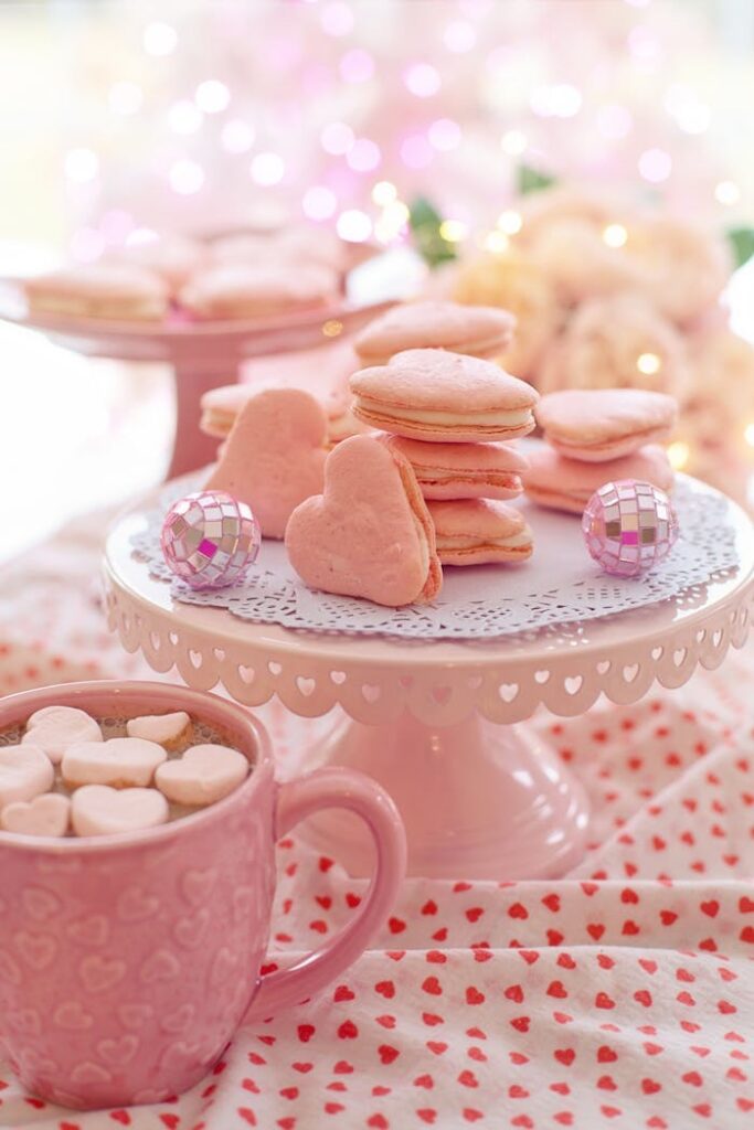 Heart-shaped pink macarons on a cake stand, perfect for Valentine's Day celebration.