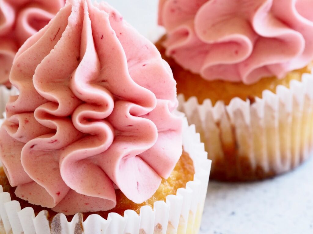 Delicious close-up image of pink-frosted cupcakes, perfect for dessert enthusiasts.